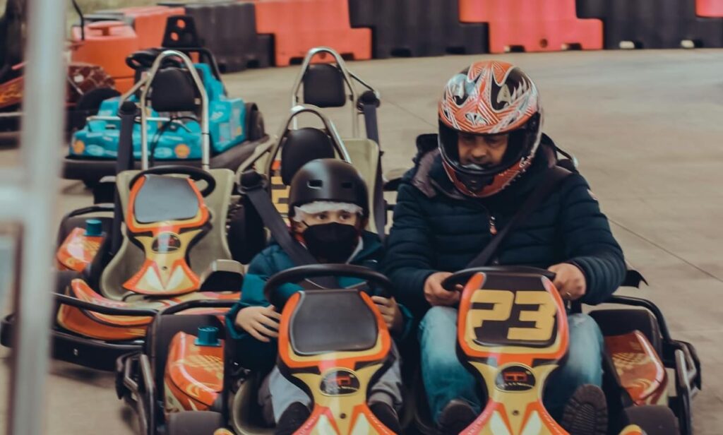 one coach is teaching a child how to play go kart